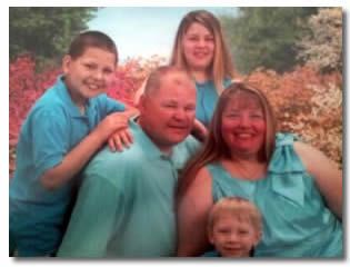 A family posing for a picture with flowers in the background