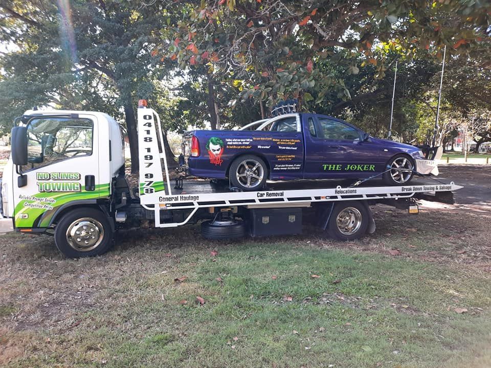 Tow Truck Transporting a Blue Car. Truck is White and Green — No Slings Towing in Glendale, QLD