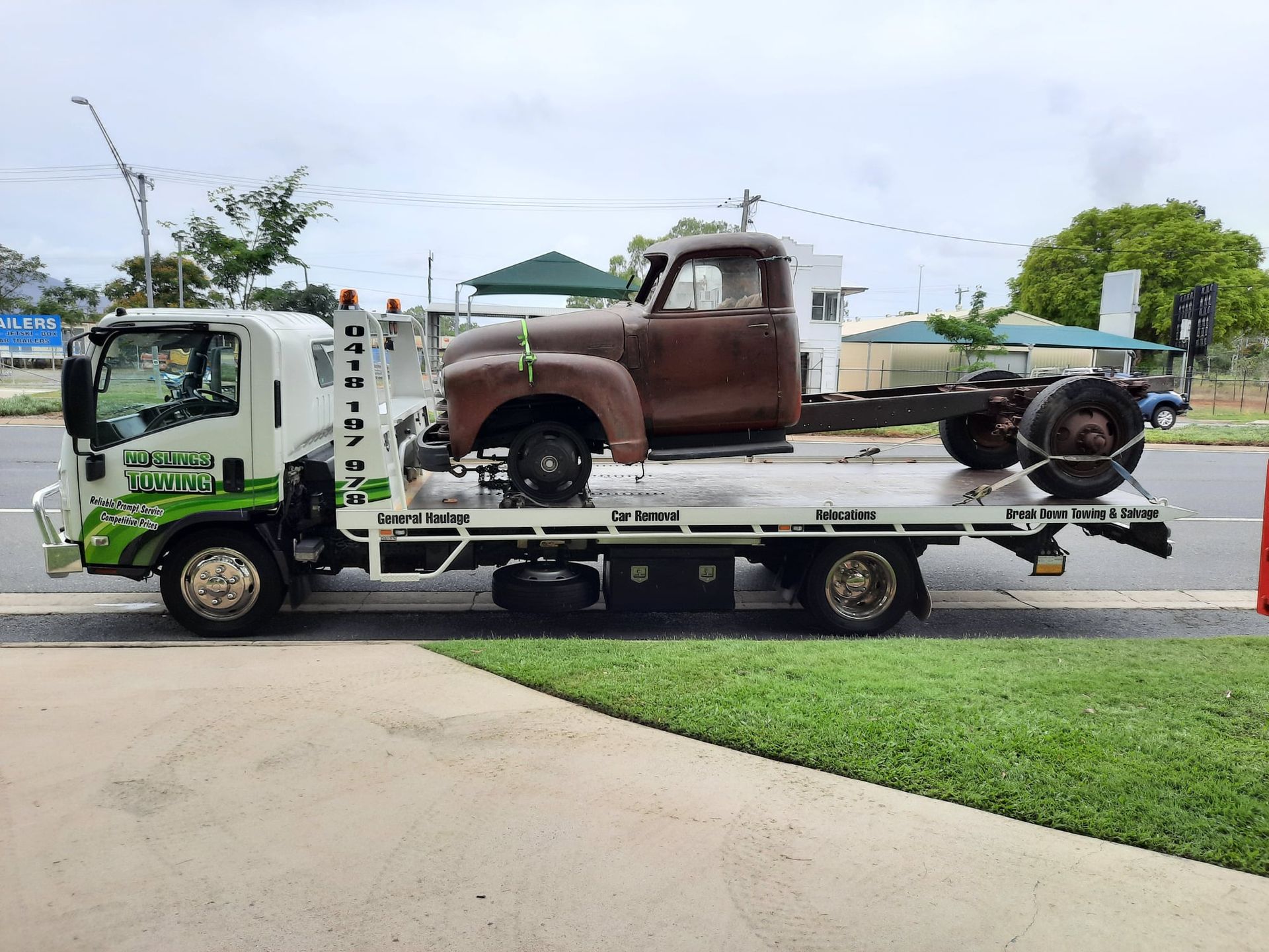 Flatbed Tow Truck Transporting a Rusty, Vintage Truck Cab — No Slings Towing in Glendale, QLD
