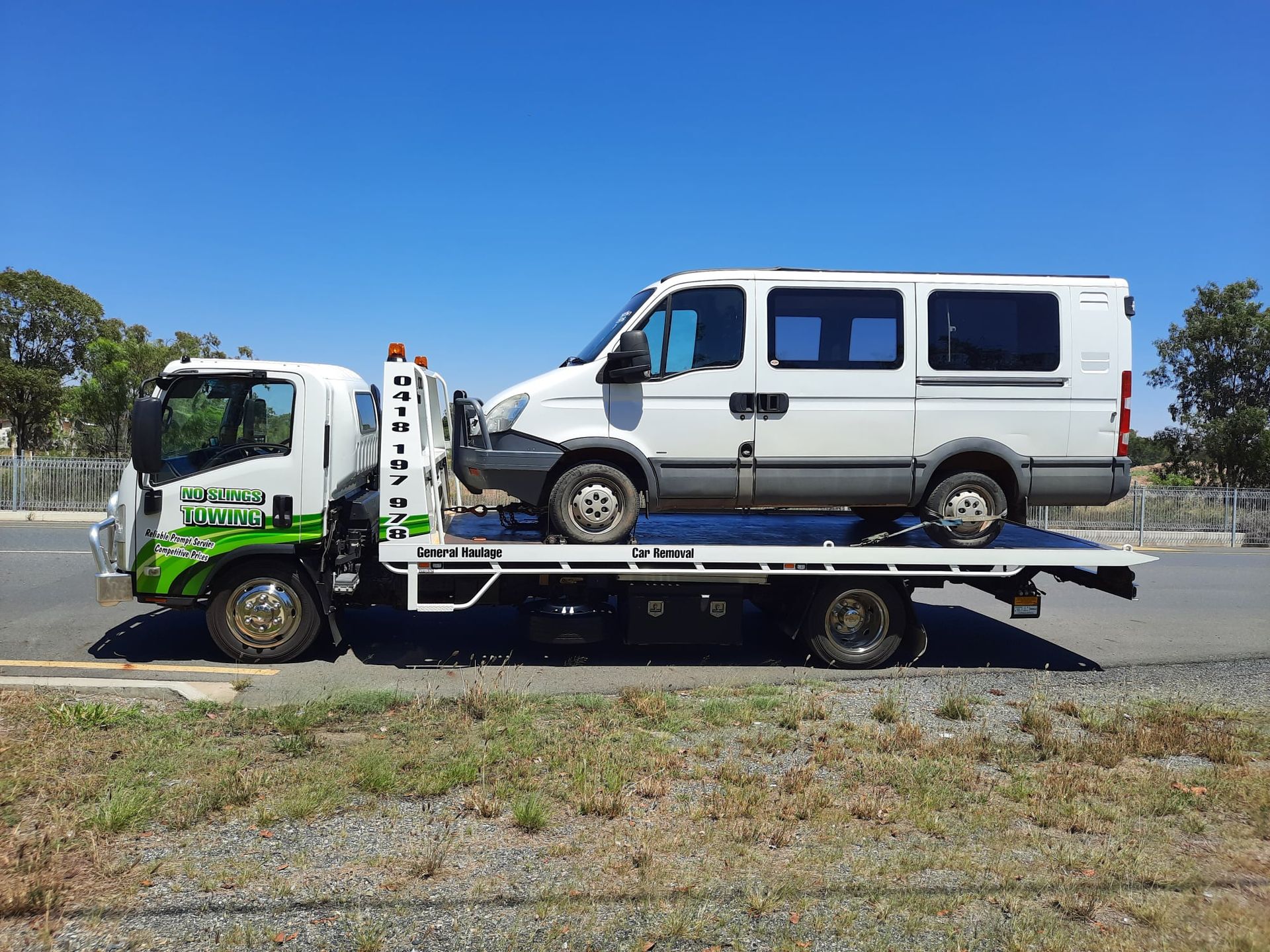 White Van Loaded on a Tow Truck on a Sunny Day — No Slings Towing in Glendale, QLD