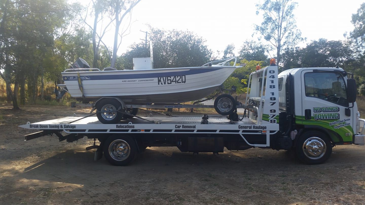 Tow Truck Carrying a Boat on Its Flatbed in an Outdoor Setting — No Slings Towing in Glendale, QLD