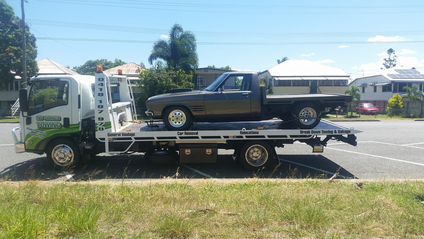 Tow Truck Carrying a Brown Pickup Truck on a Flatbed — No Slings Towing in Glendale, QLD
