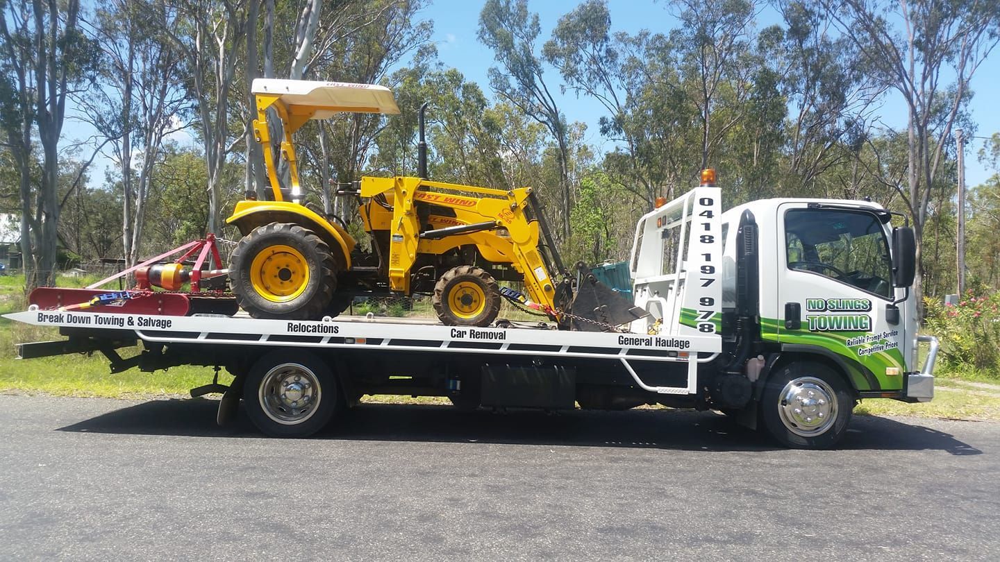 Yellow Tractor on a Flatbed Tow Truck, Parked on a Road — No Slings Towing in Glendale, QLD