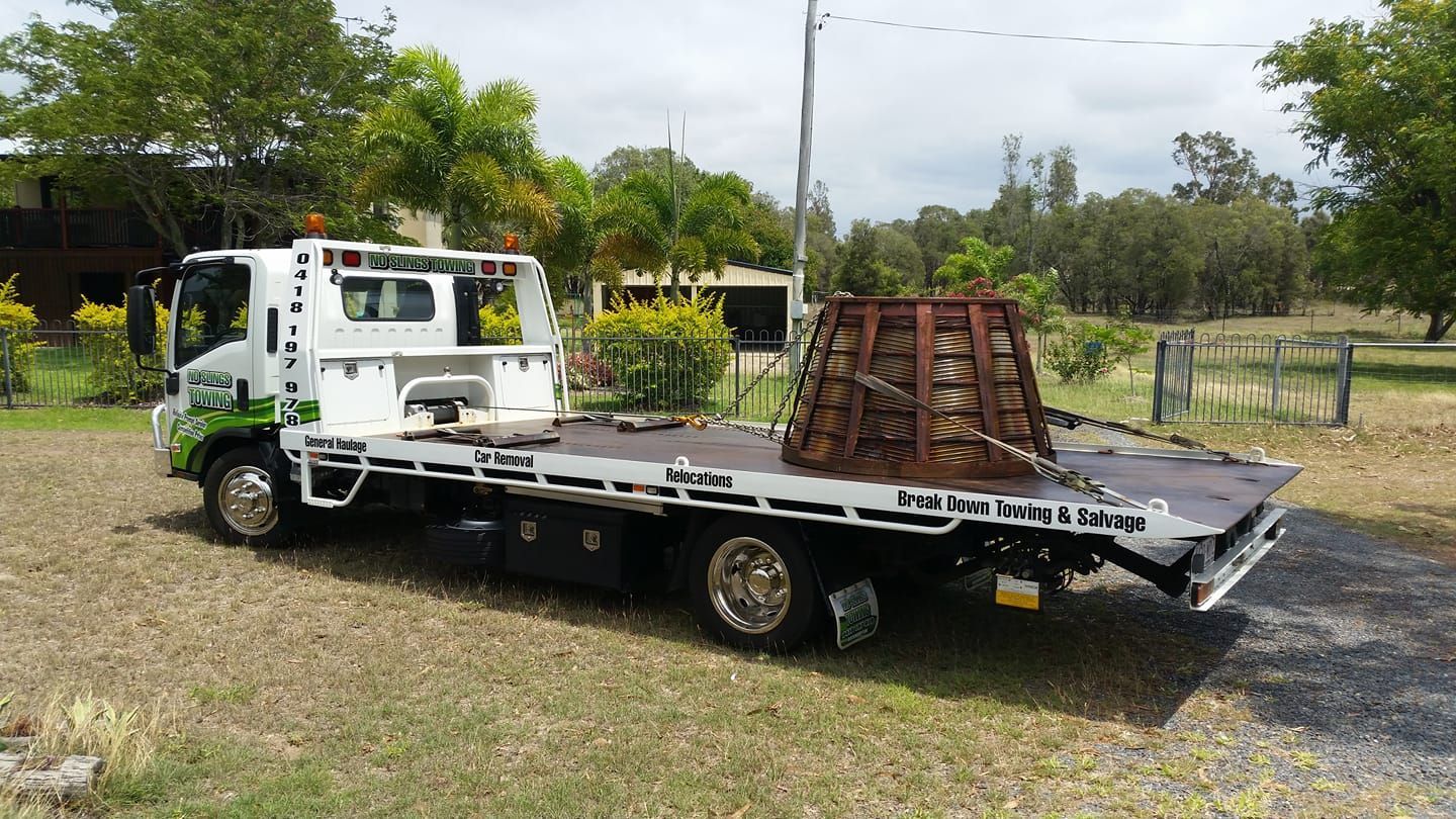 White Tow Truck With a Wooden Structure Secured to Its Bed — No Slings Towing in Glendale, QLD
