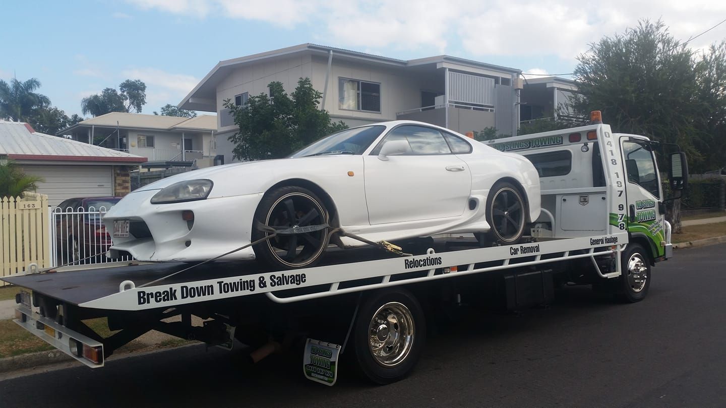 White Toyota Supra on a Tow Truck on a Residential Street — No Slings Towing in Glendale, QLD
