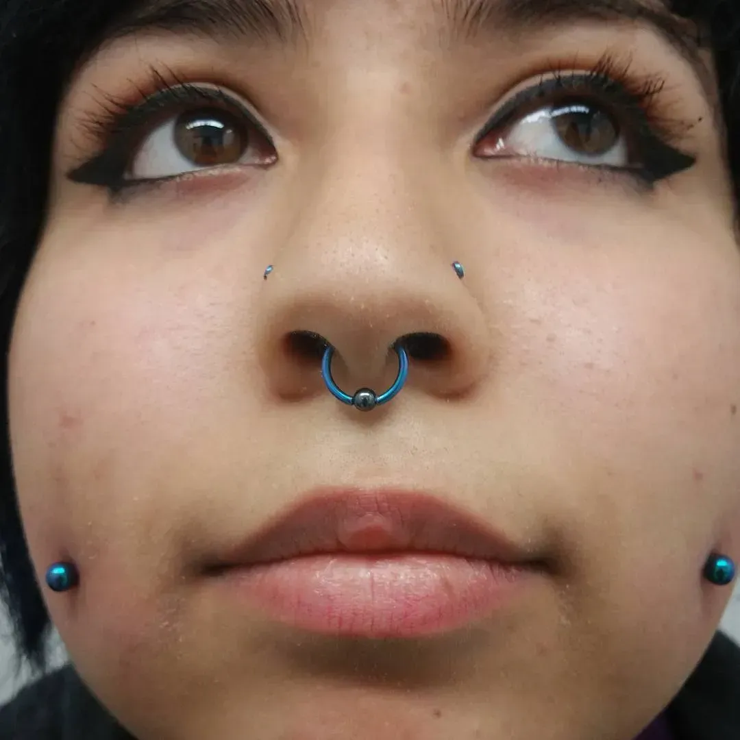 A close up of a woman 's face with a nose ring