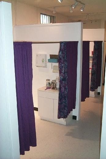 A dressing room with purple curtains and a mirror