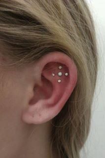 A close up of a woman 's ear with a piercing.