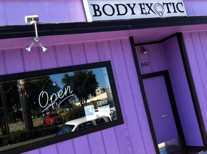 A body exotic store front with a window that says open