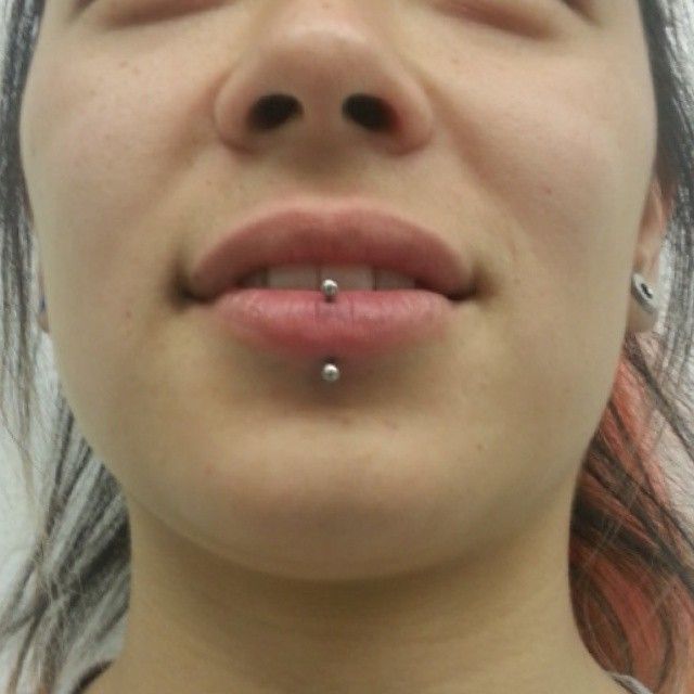 A close up of a woman 's face with a lip piercing