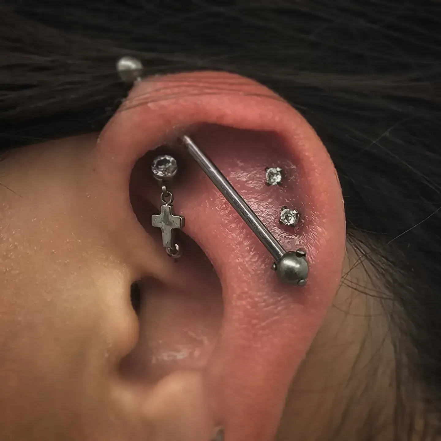 A close up of a woman 's ear with multiple piercings