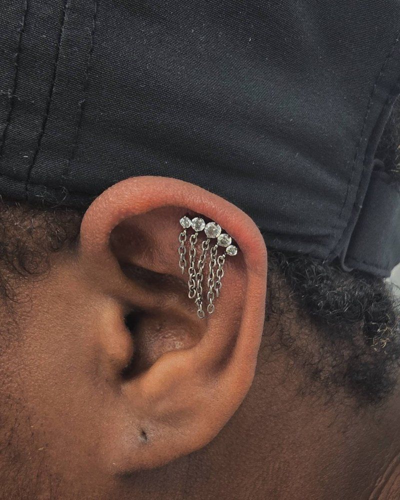 A close up of a person 's ear with a chain earring