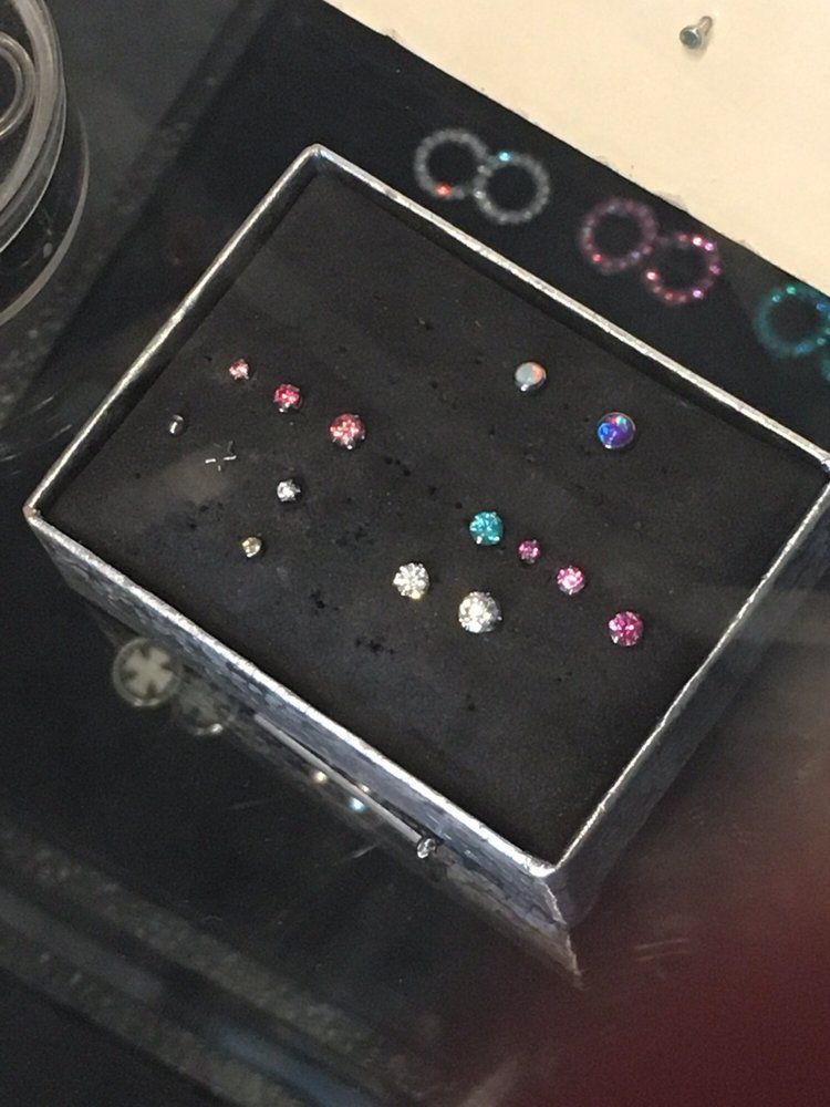 A box of earrings sits on a glass table
