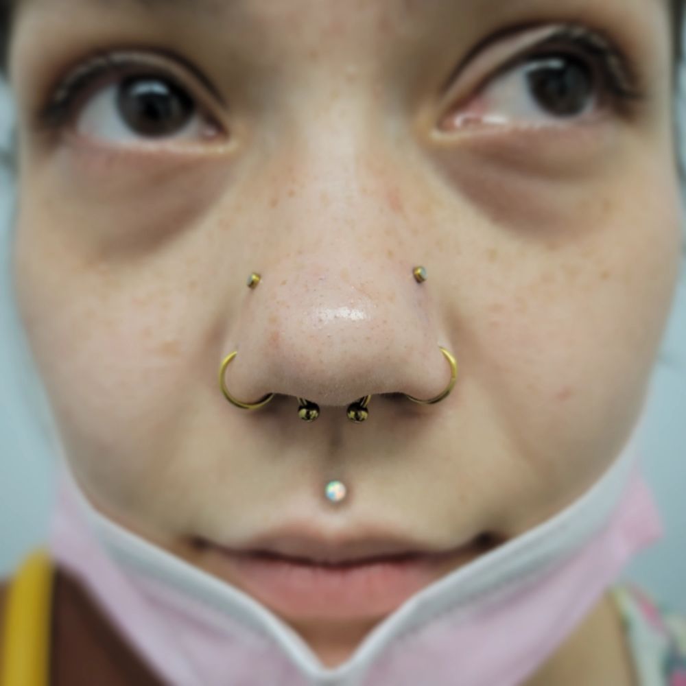 A close up of a woman 's face with a nose ring.