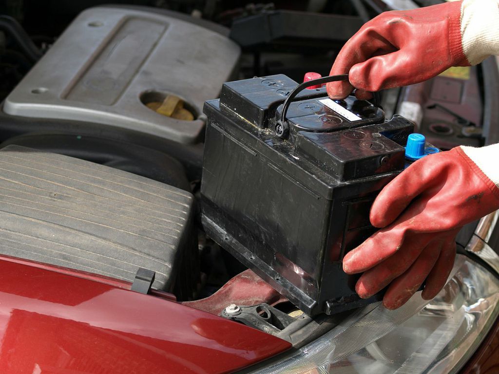 car mechanic replacing the battery in a car