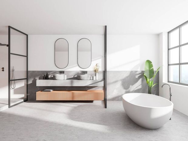 A bathroom with a bathtub , sinks , mirrors and a window.