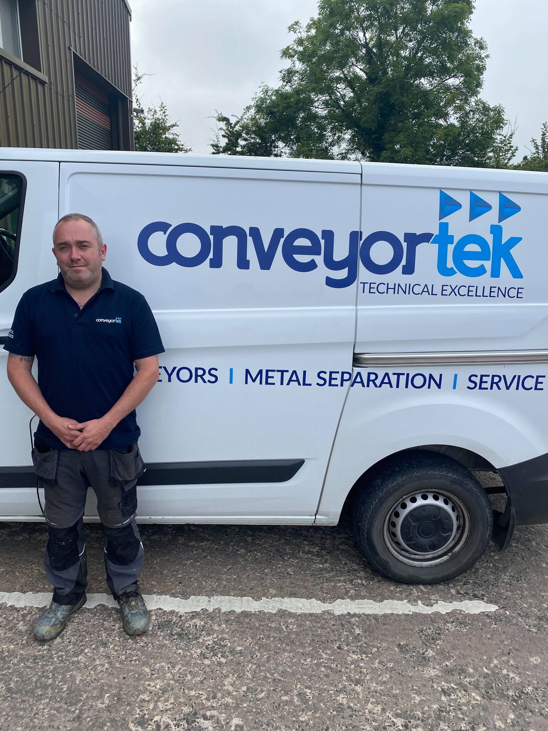 A man is standing in front of a conveyortek van.