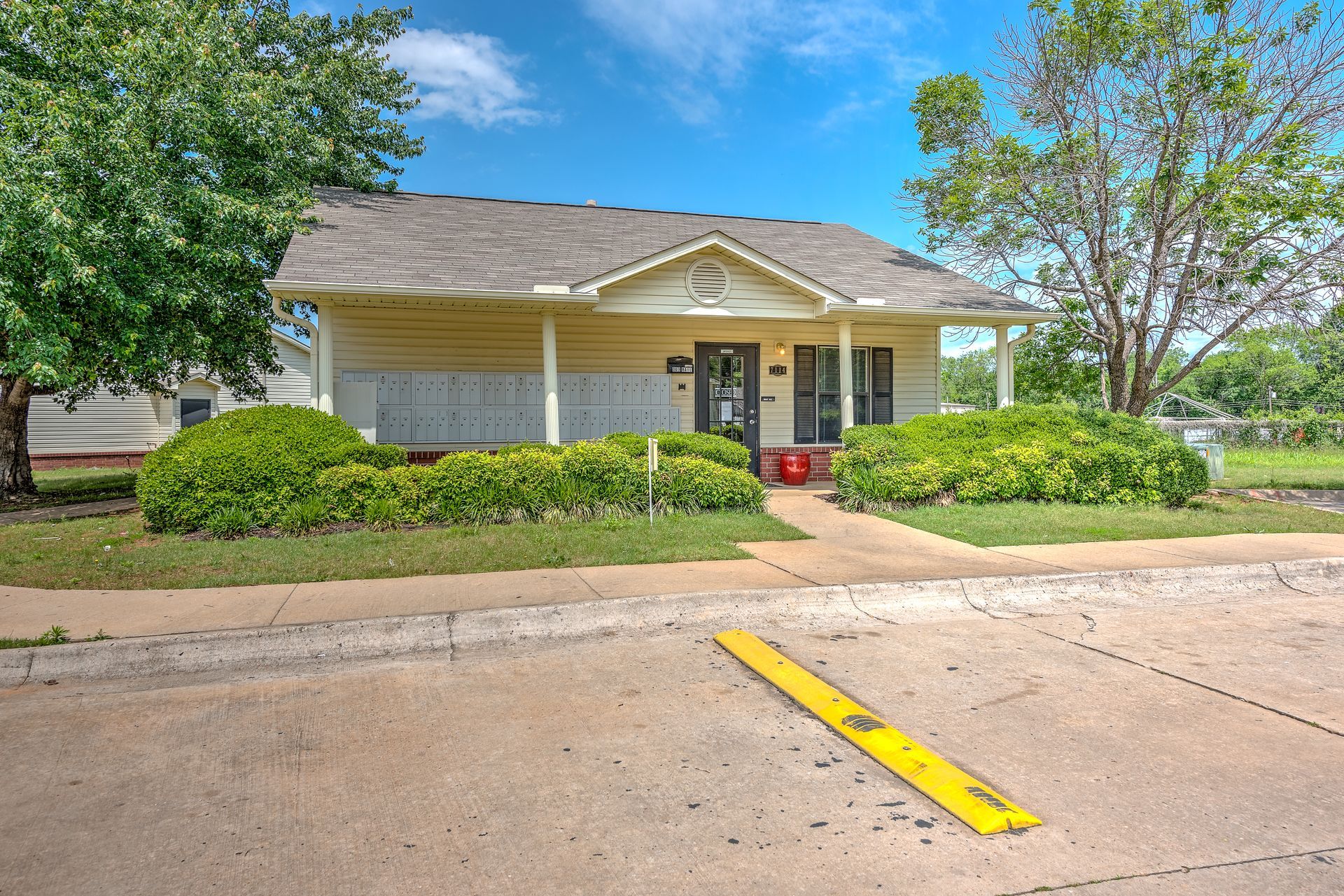 A white house with a gray roof and a yellow curb