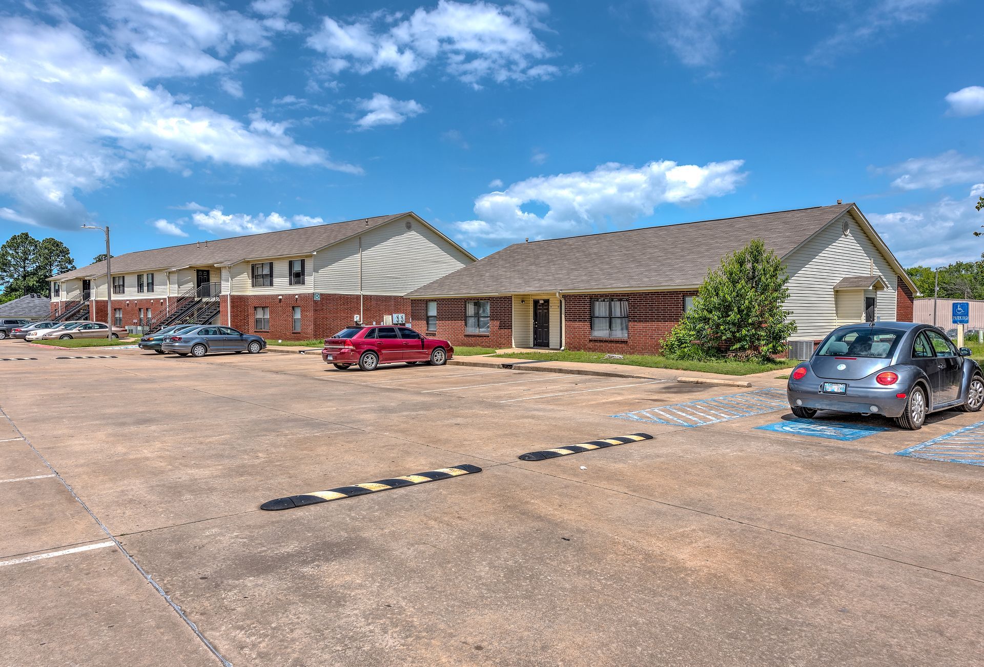 A parking lot with cars parked in front of a building.