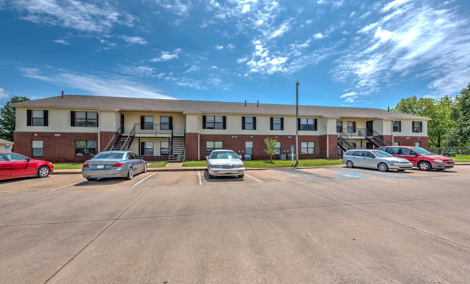 A large apartment building with cars parked in front of it.