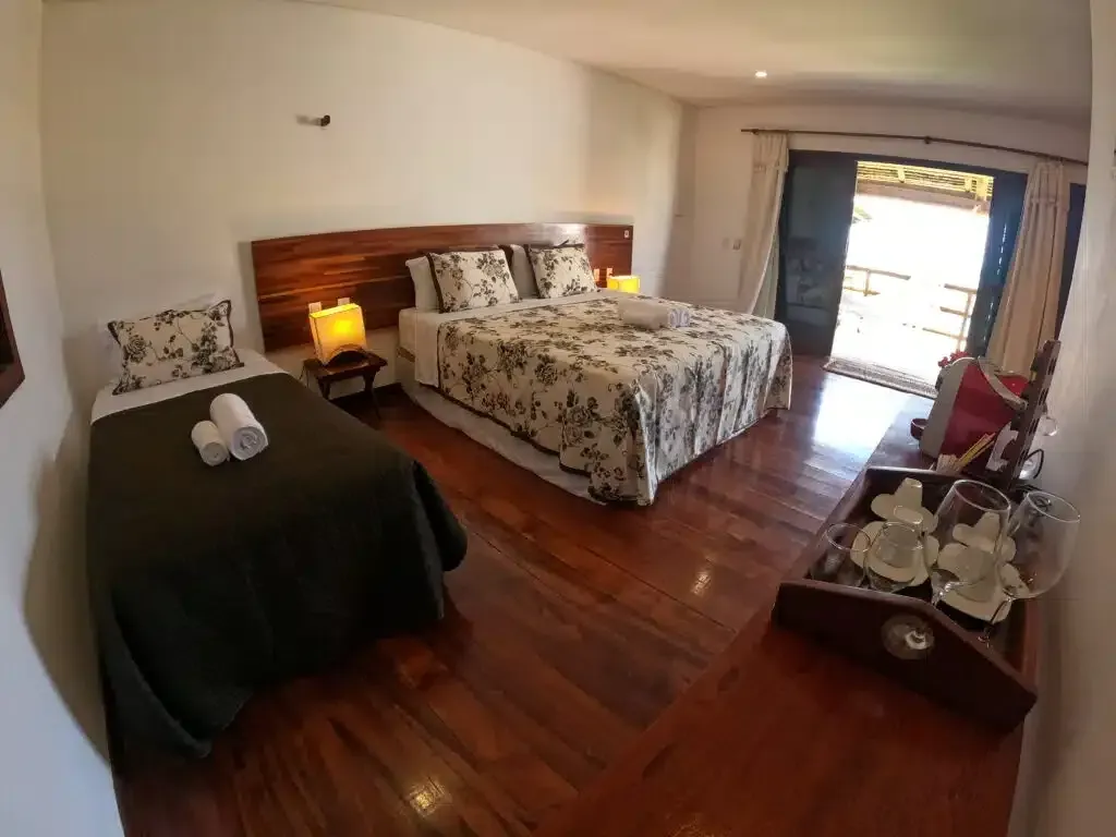 Um quarto de hotel com uma cama grande e duas camas pequenas