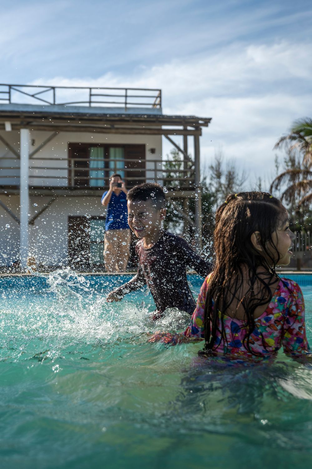 Um menino e uma menina estão brincando em uma piscina.