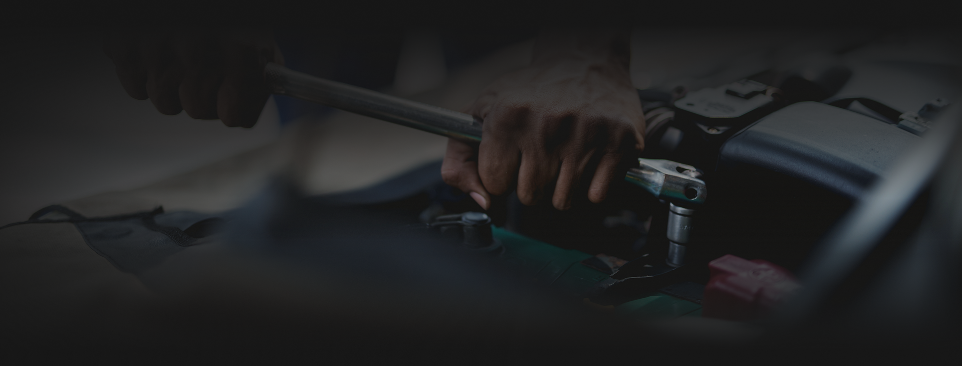 Hand reaching to adjust a car’s center console controls in a dim interior