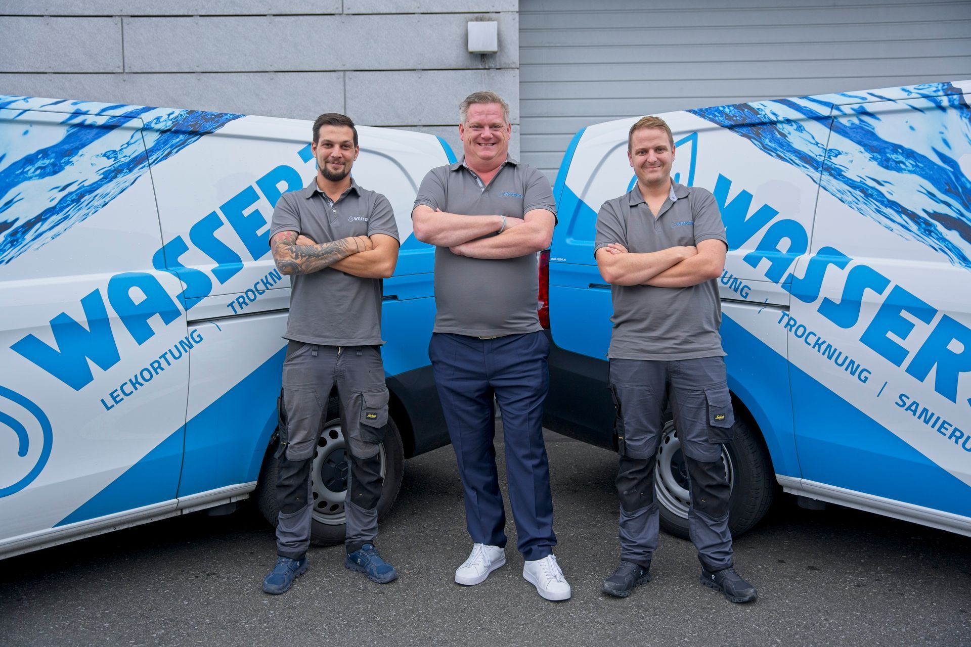 Ein Arbeiter in blauer Uniform und Schutzhelm inspiziert Rohrleitungen mit einer Taschenlampe