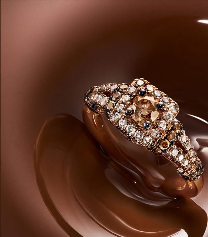 Diamond ring with brown and white stones, set in a chocolate-colored liquid.