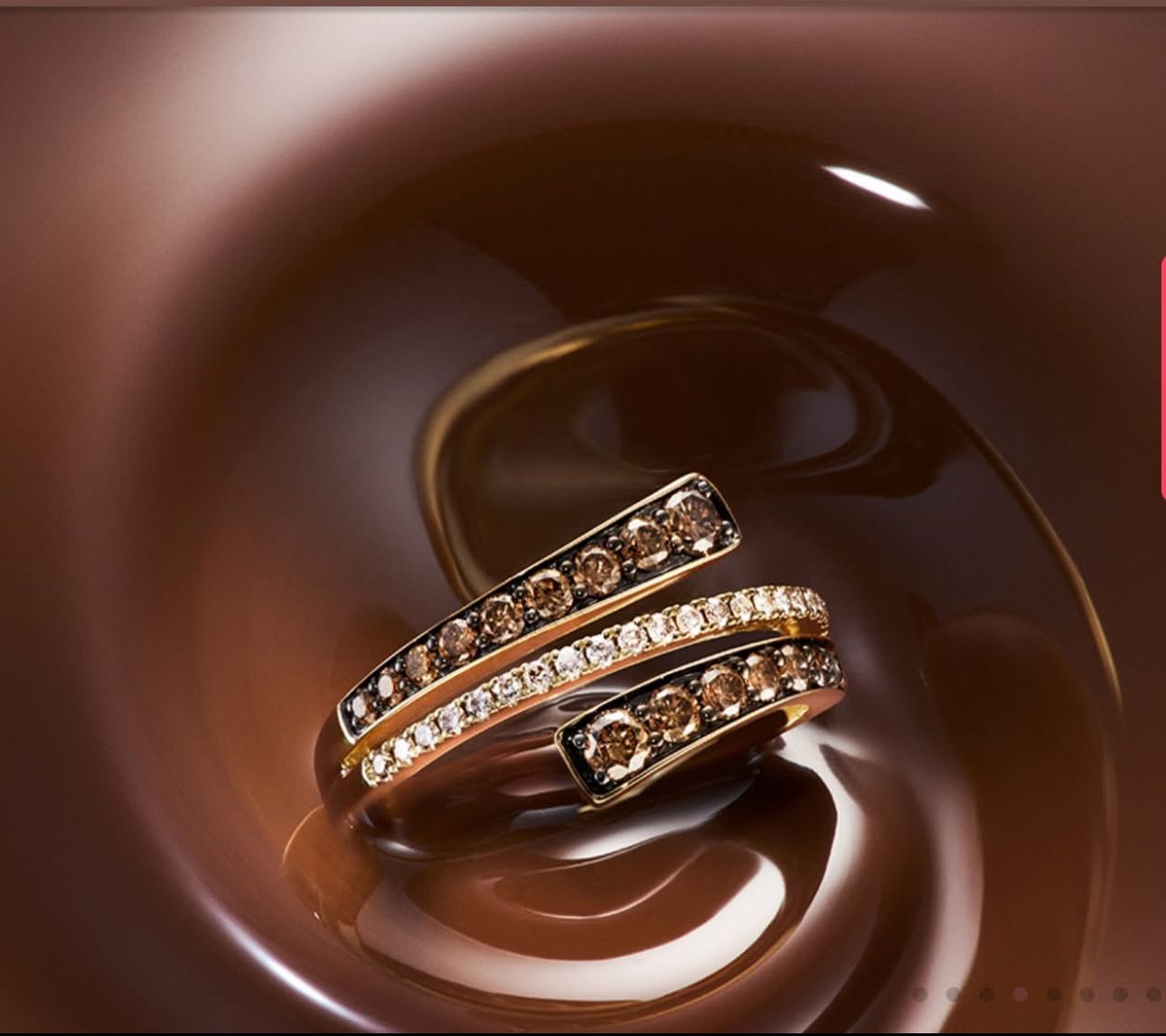 Gold ring with brown and white diamonds, set against swirling brown liquid.