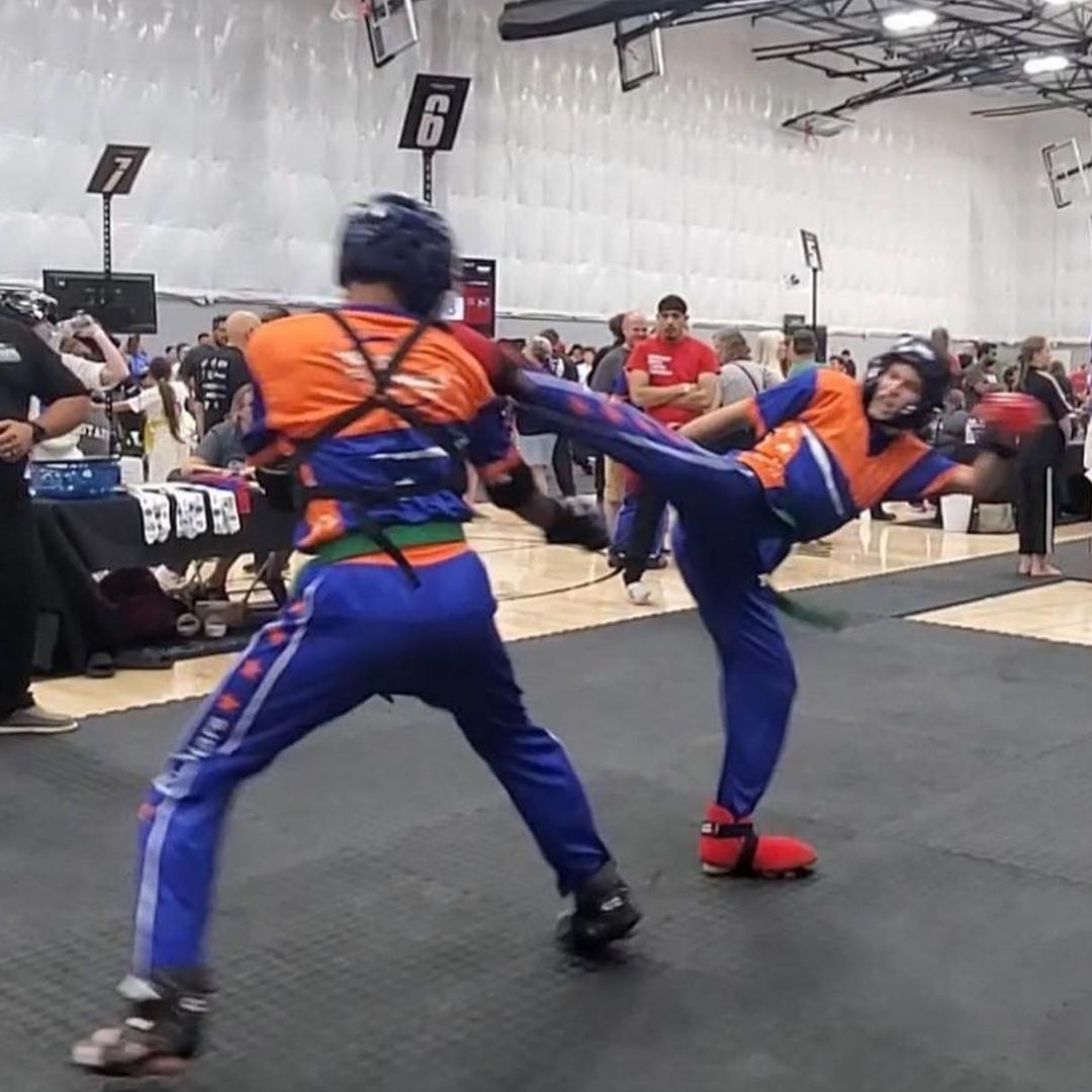 Two people practicing Brazilian Jiu-Jitsu on a mat; one in a black gi, one in a white gi, grappling.