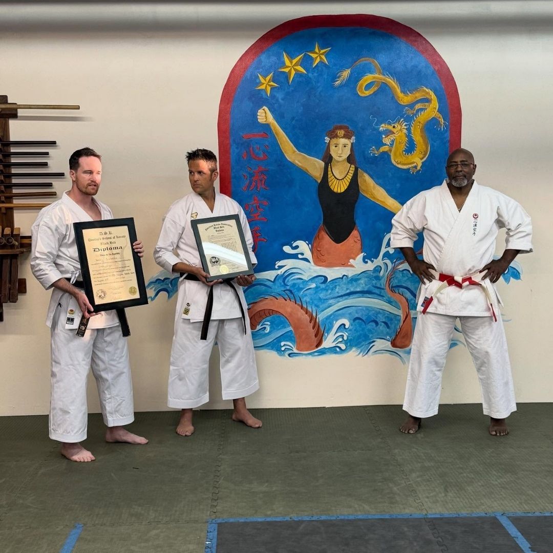Two men grappling on a mat, one in blue, the other in black.