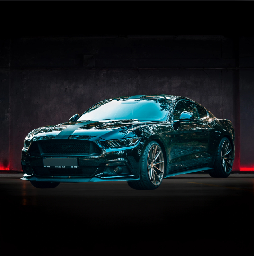 Una Ford Mustang nera è parcheggiata in un garage buio.