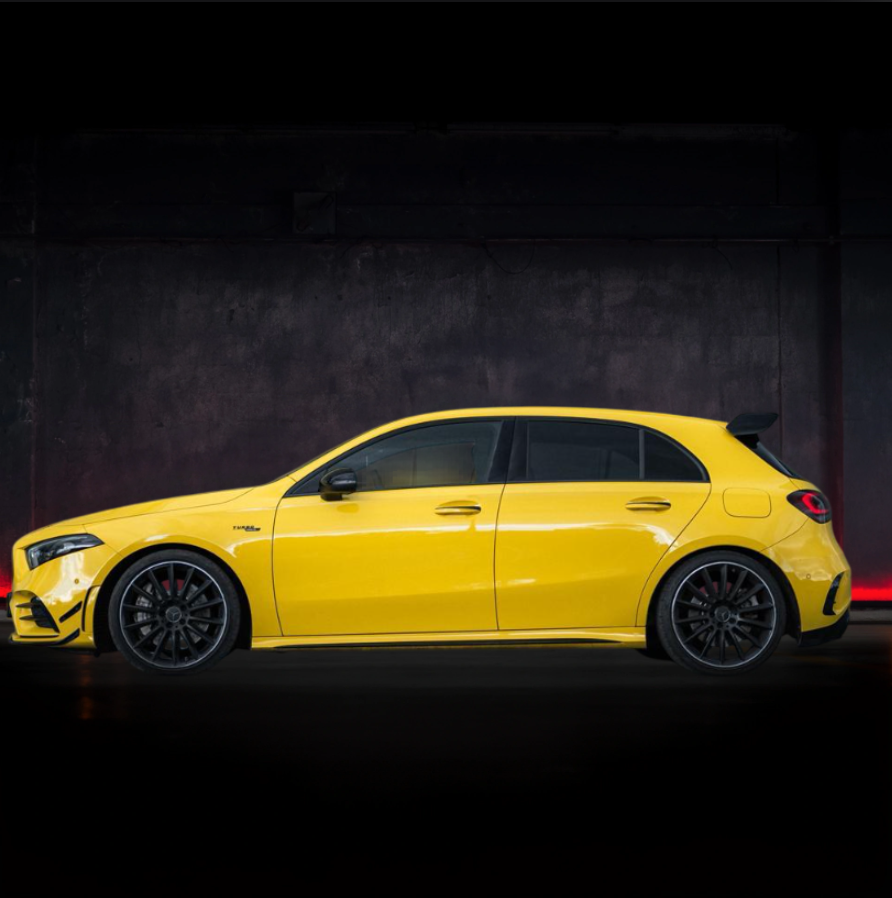 Mercedes-Benz Classe A hatchback gialla parcheggiata, cerchi neri, sfondo scuro con dettagli rossi.