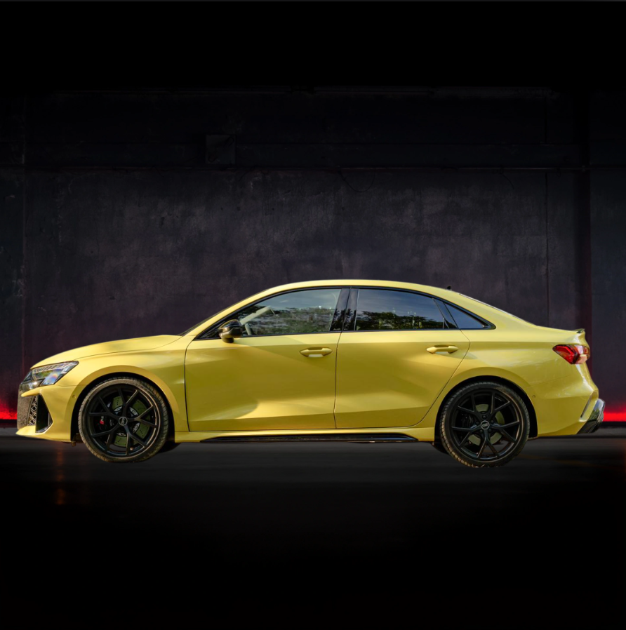 Un'auto gialla è parcheggiata davanti a un muro scuro.