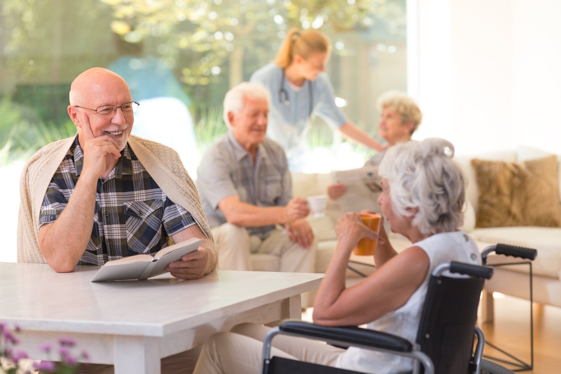 A group of elderly people sit around a table.