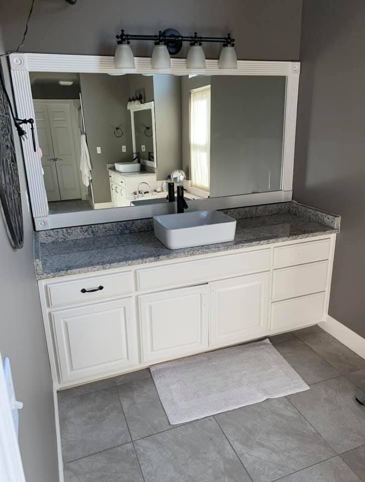 A bathroom with two sinks and a large mirror.