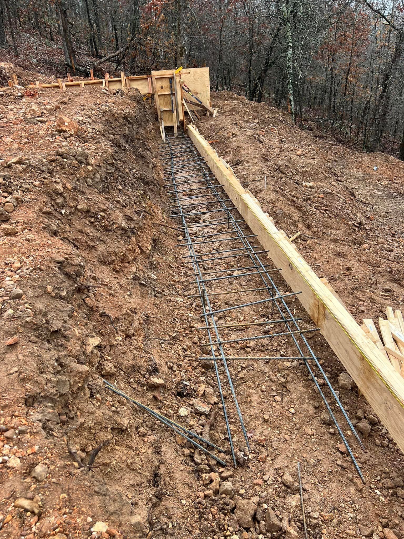A wooden fence is being built on top of a dirt hill.
