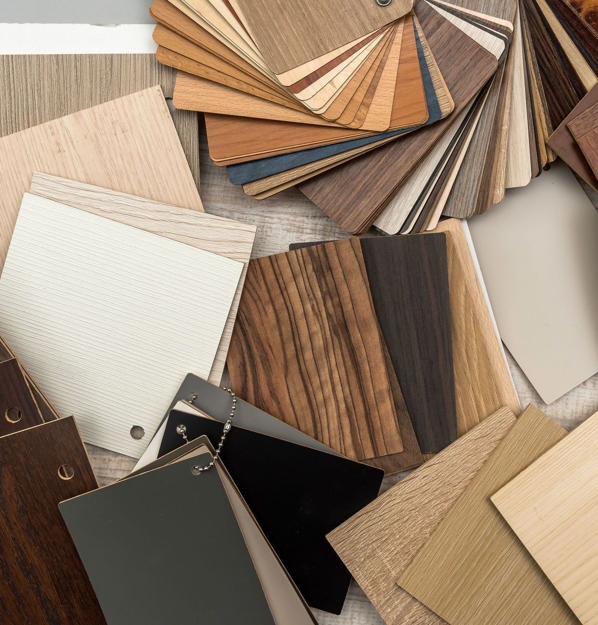 Various wood and laminate samples arranged on a light-colored surface, showing different colors and textures.