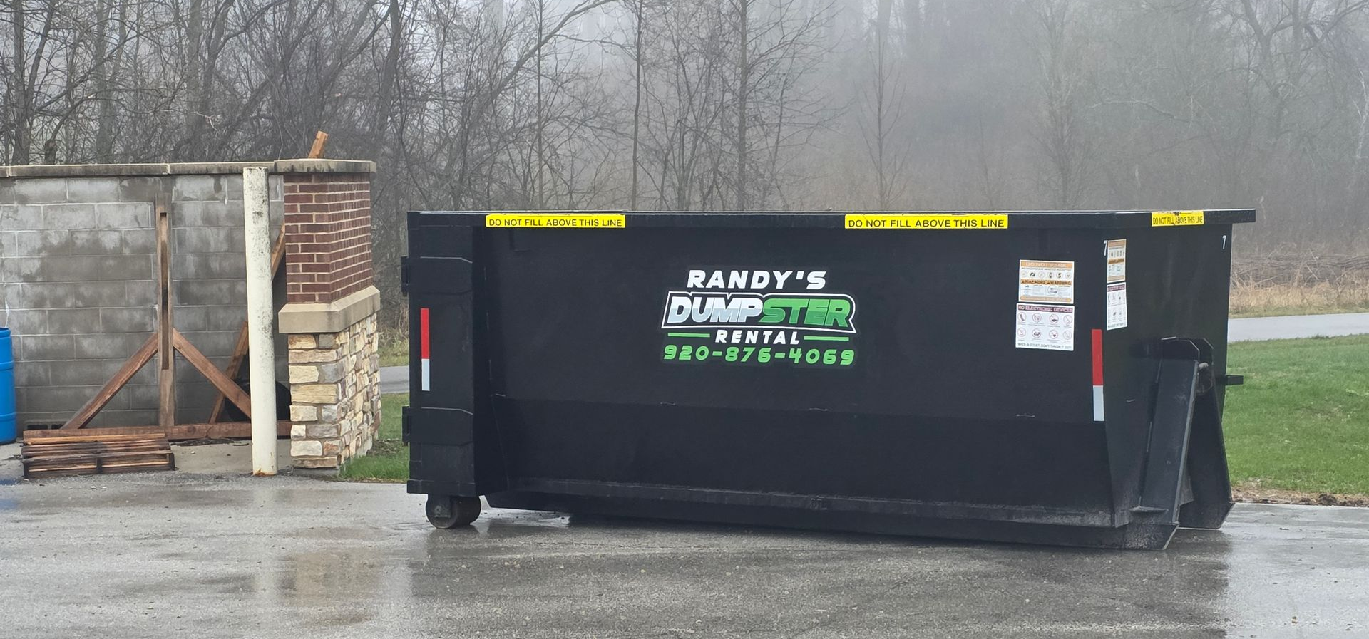 Randy's Dumpster Rental truck with dumpster on site
