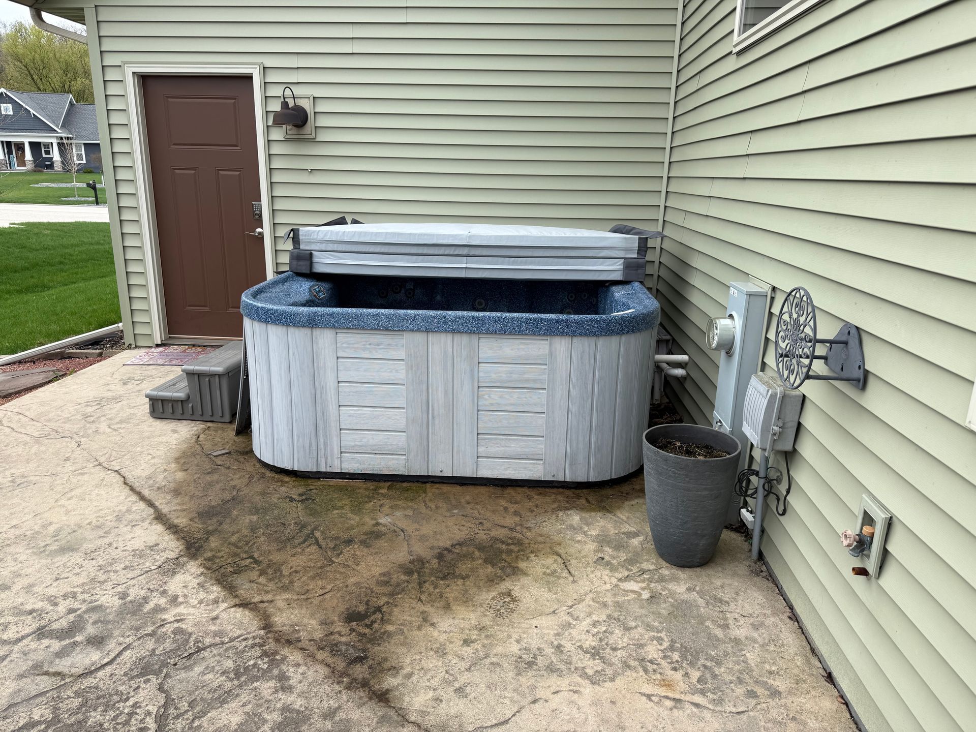 A hot tub is sitting on the side of a house.