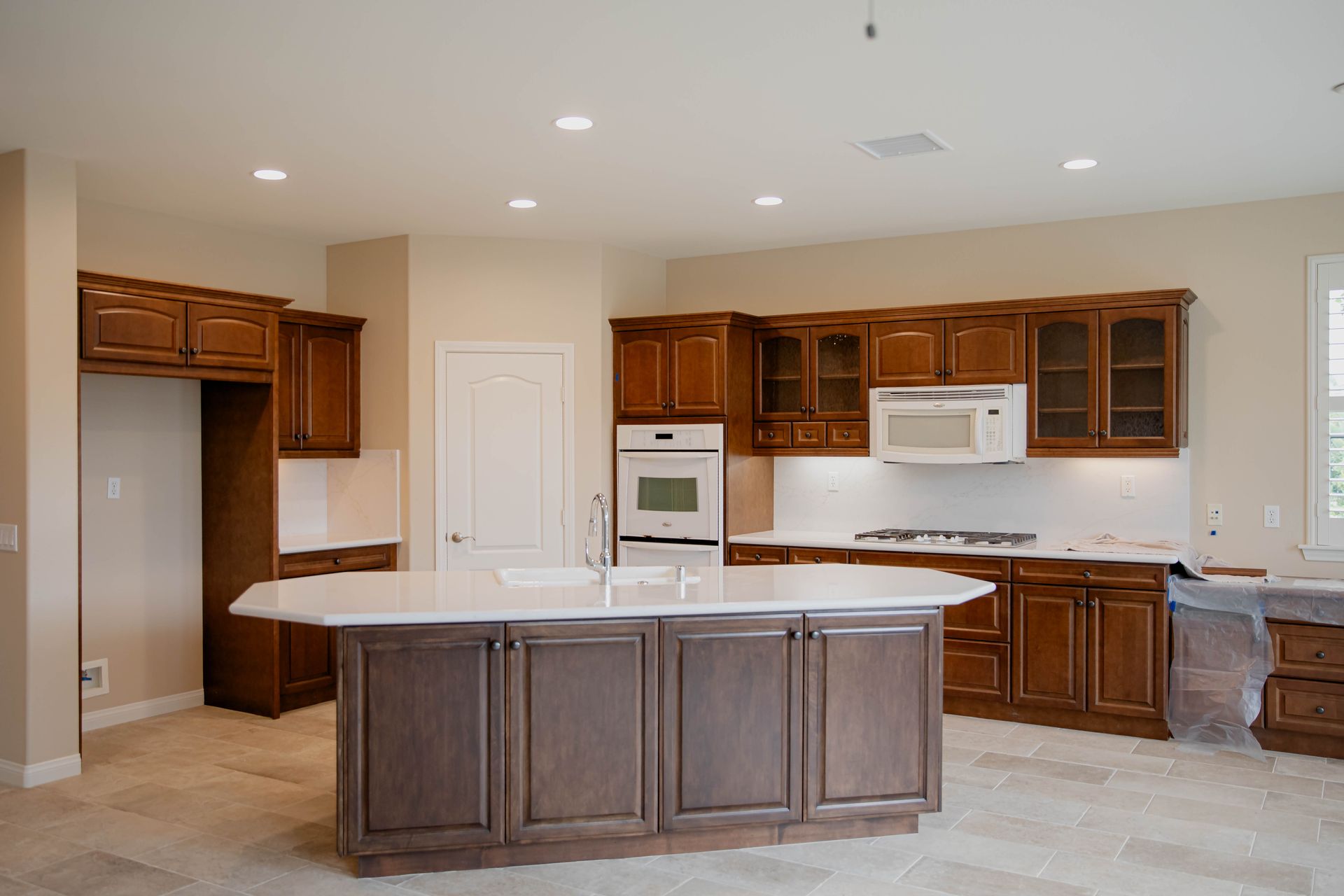 An empty kitchen with wooden cabinets and a large island.