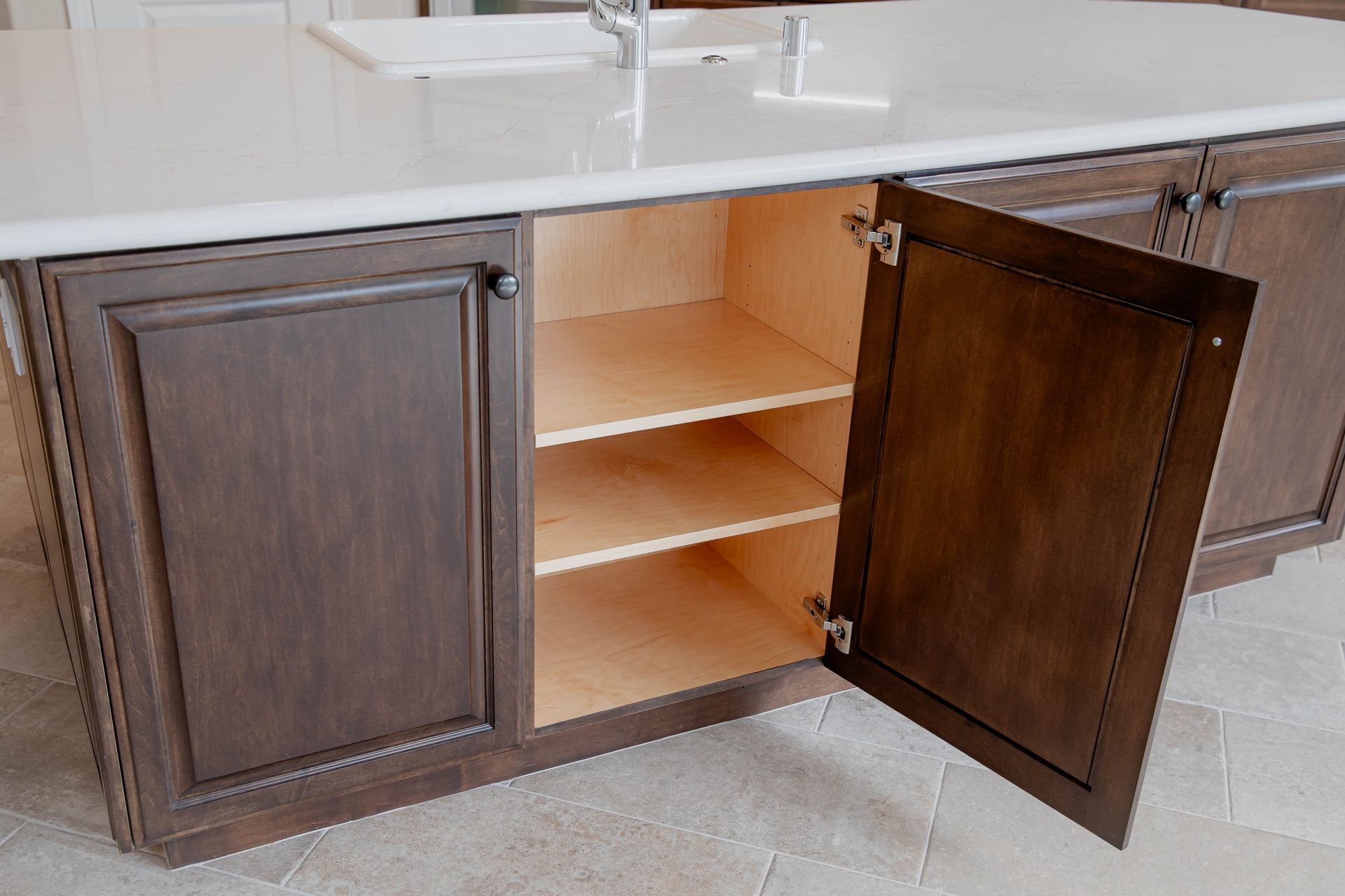 A kitchen island with wooden cabinets and shelves with the doors open in Vista, California.