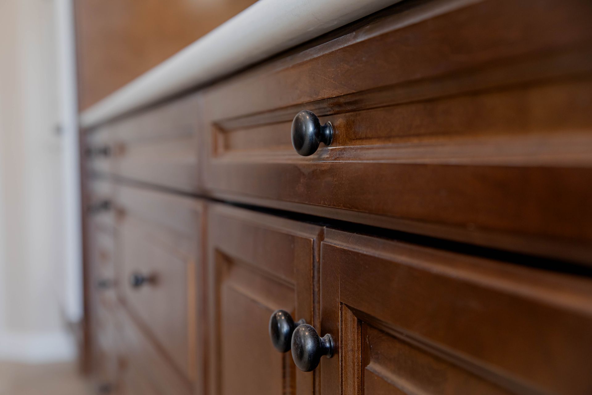 A close up of a wooden cabinet with black knobs in a kitchen in Vista, California.
