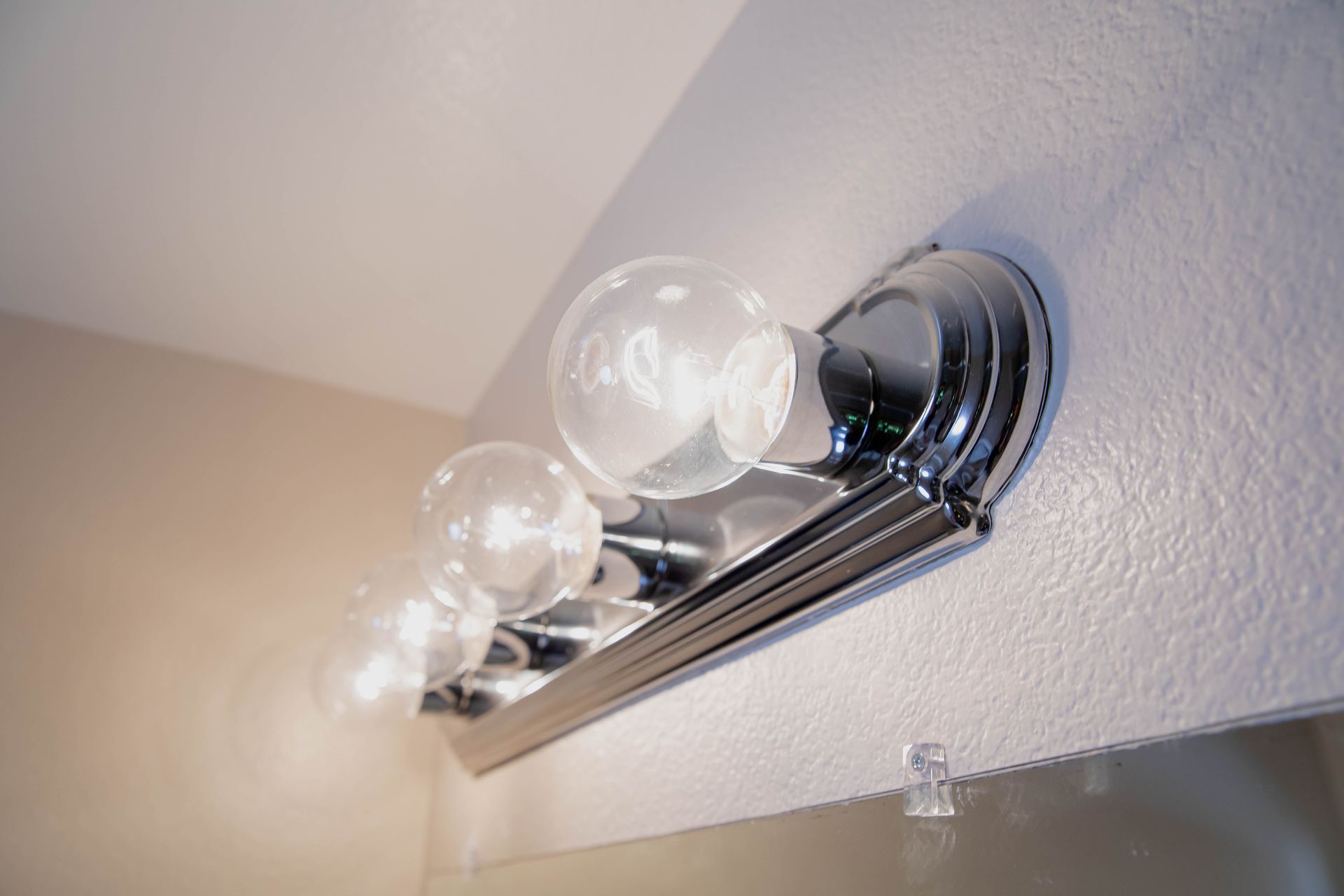 A bathroom vanity light with three bulbs hanging from the ceiling in San Marcos, California.