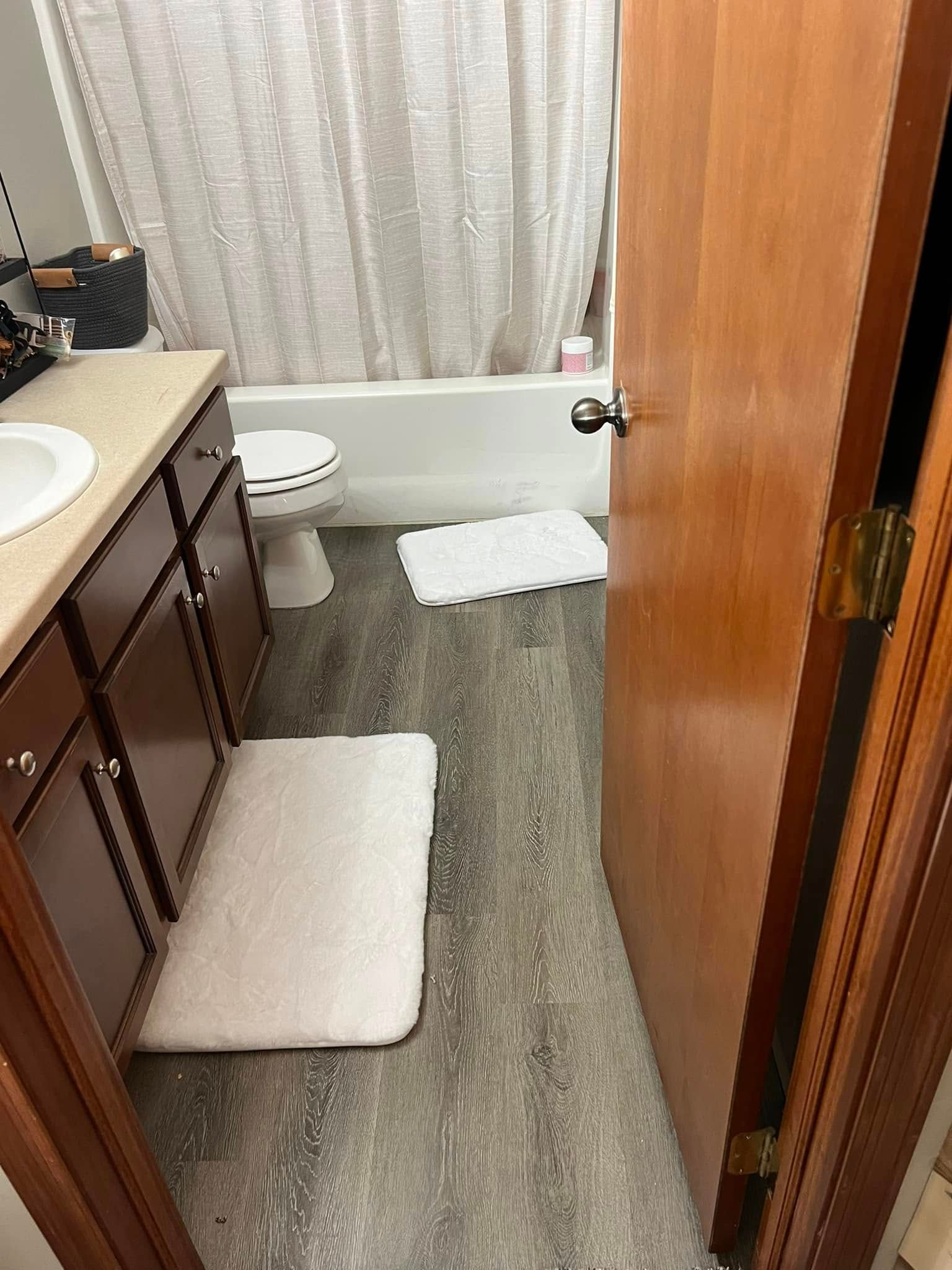A bathroom with a sink , toilet , bathtub and door.