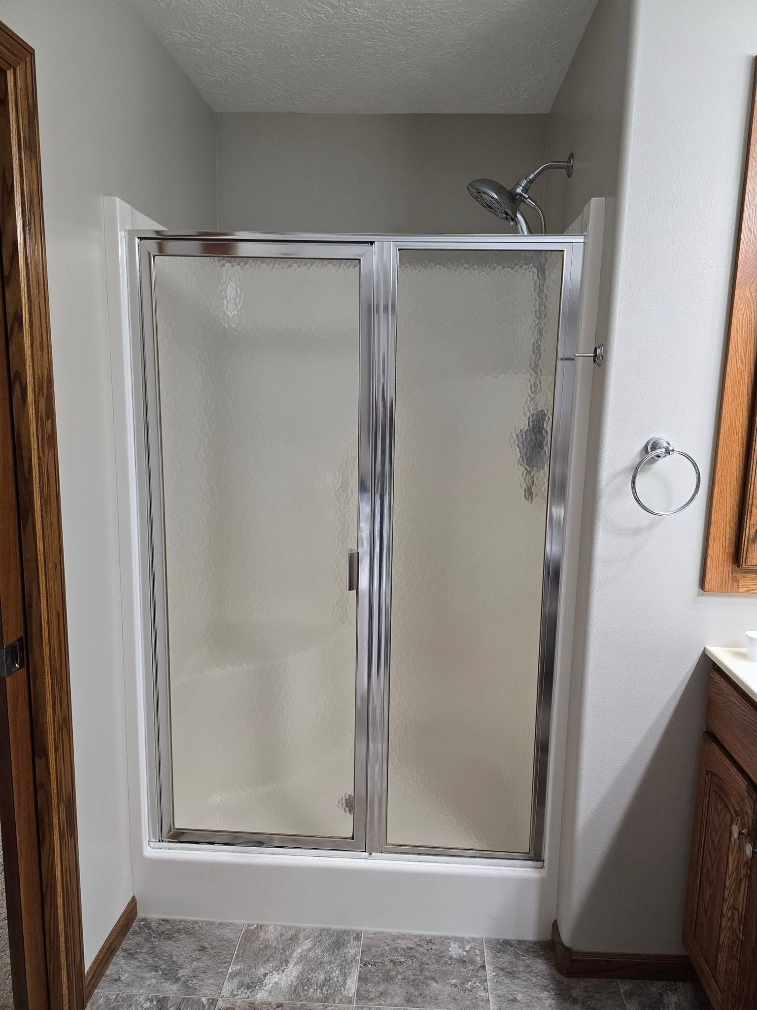 A bathroom with a walk in shower and a sink.