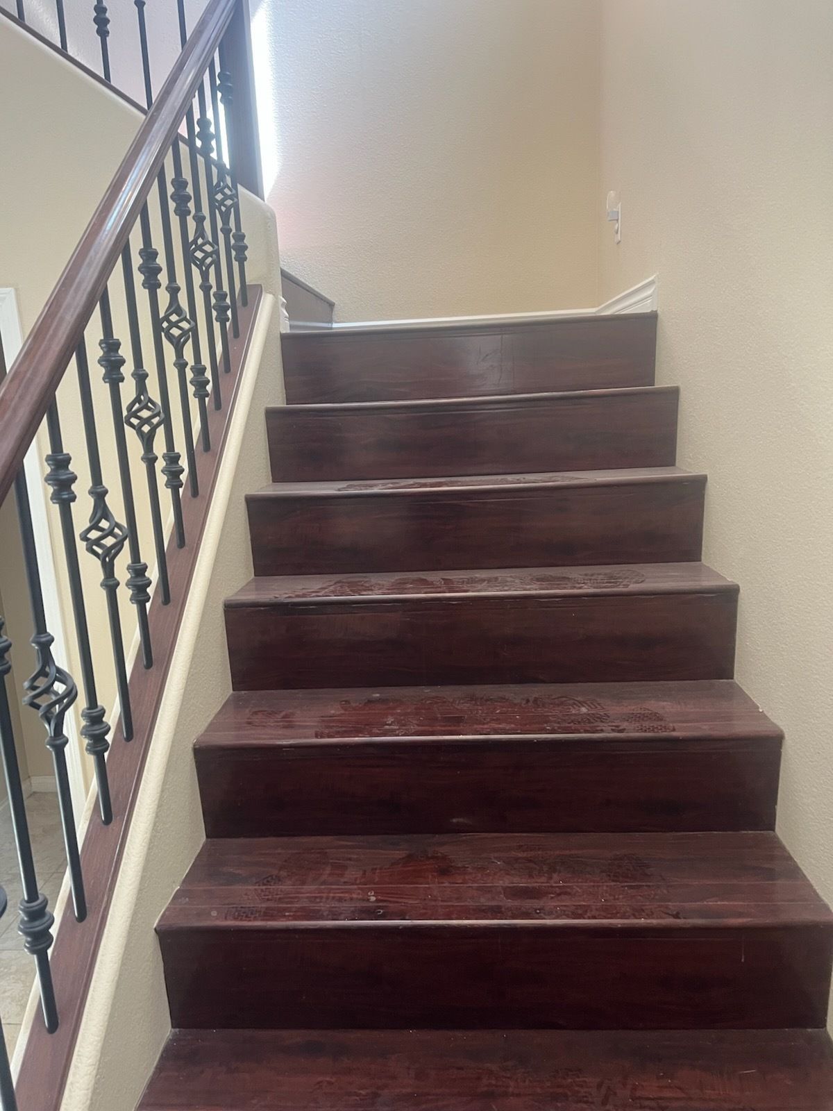 Wooden staircase with dark treads, metal railing, and light-colored walls.