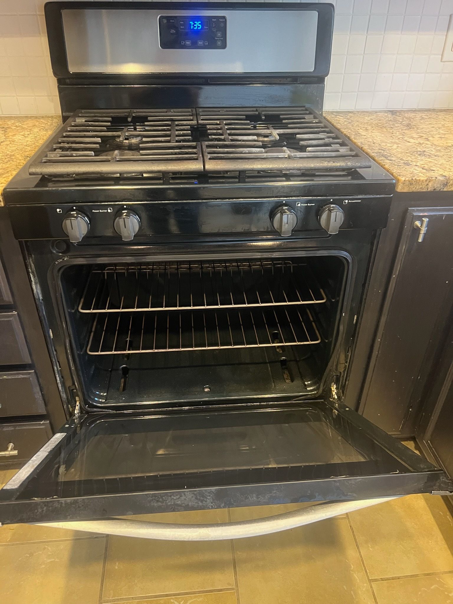 Black gas range with the oven door open.