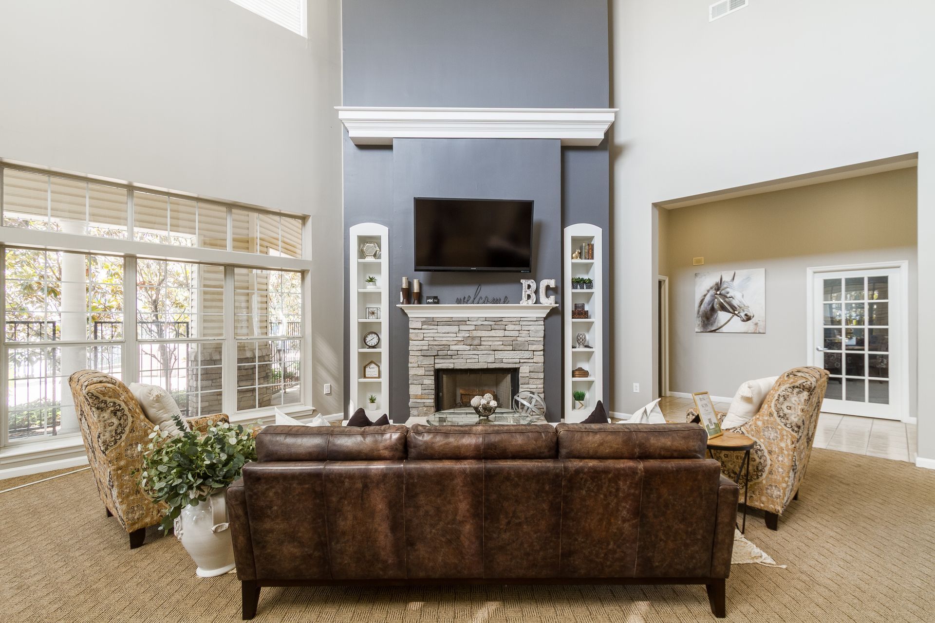 Resident clubhyouse with high ceilings, fireplace, and leather sofa. Tour Bridle Creek to experience our Lexington, KY apartments for rent in person.